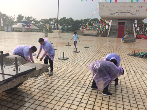 1498008529227552.jpg 志愿者雨中收伞.jpg